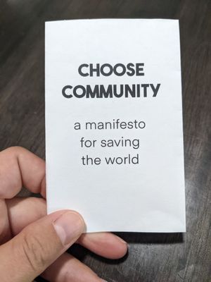 the front of a small zine on white paper, which reads 'Choose Community: a manifesto for saving the world'