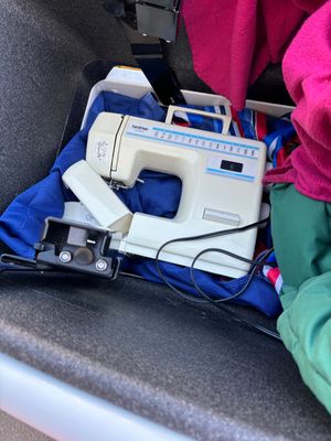 a Brother sewing machine in the bottom of the front bucket of an Urban Arrow cargo bike
