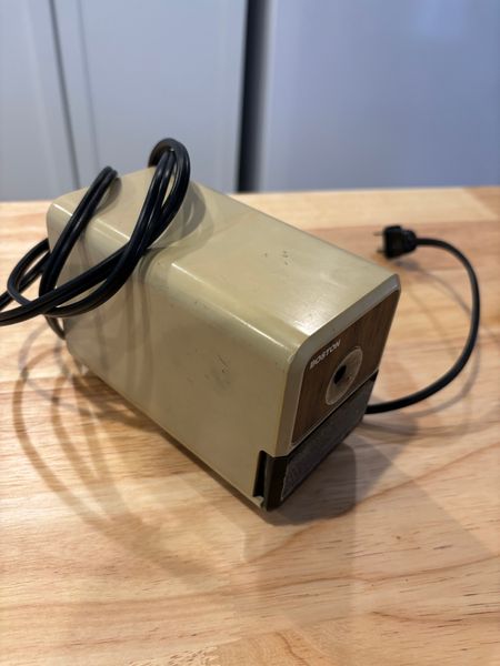 a bog-standard, used grey electric pencil sharpener